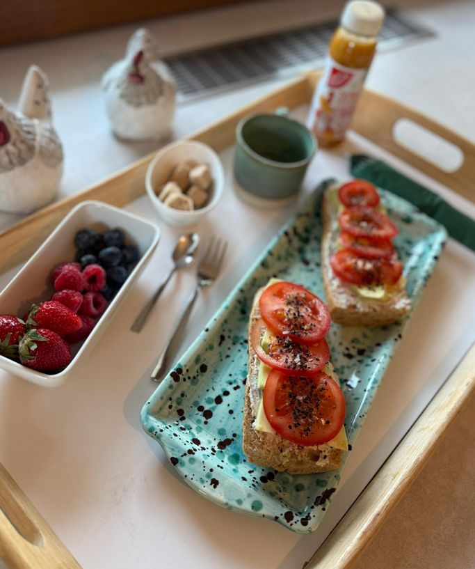 Veganes Frühstück „Deftig“: belegte Brote mit Tomate und Avocado, dazu Beeren und Saft